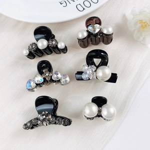 Detail of mini hair claws set featuring elegant pearls and sparkling rhinestones