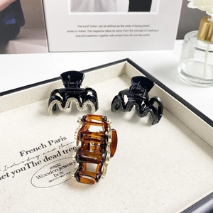 Detailansicht eleganter wellenförmiger Haarklammern mit Strass und Bernstein-Harz