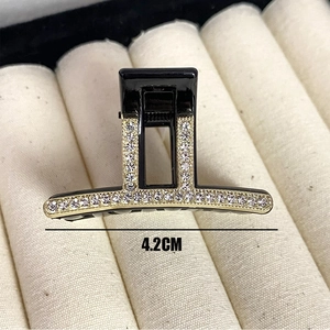 Sparkling rhinestone hair claw clip in black and gold with 4.2cm width on display