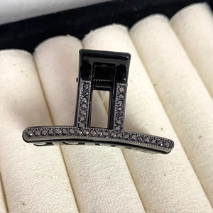 Close-up of luxury black hair claw clip with sparkling rhinestones on jewelry display