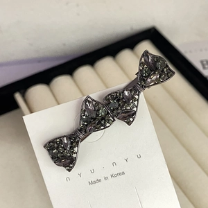 Close-up of triple bow hair clip with grey rhinestones and elegant alloy base