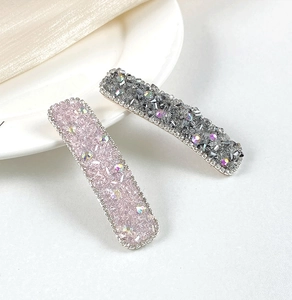 Detail of luxury rectangle hair clips with shimmering crystals and metal chain borders