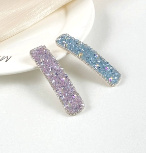 Close-up detail of luxury blue and purple crystal hair clips with silver metallic edges