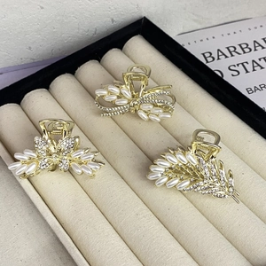 Elegantes Set aus goldenen Schmetterlings-Haarklammern mit Perlen und Strass auf Tablett