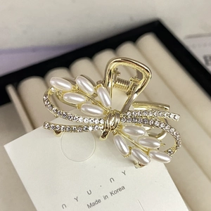 Eleganter Schmetterling Haarklammer in Gold mit Perlen und Strass auf einer Karte