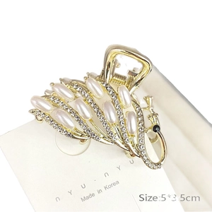 Eleganter goldener Pfau-Haarclip mit Kunstperlen und Strasssteinen auf weißer Karte