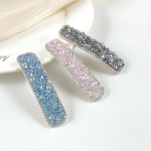 Three-piece set of rectangular crystal-encrusted hair clips in blue, pink, and grey colors