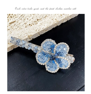 Détail d'une barrette à fleurs faite main avec cristaux bleus et monture en métal argenté