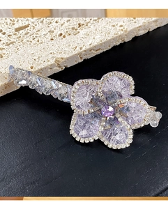 Détail d'une barrette fleur en cristal lilas faite main avec des strass étincelants