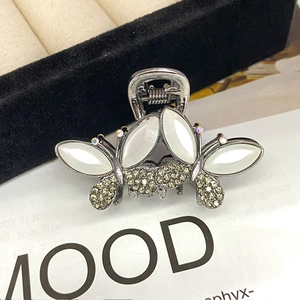 Detailed close-up of opal butterfly hair claw clip with rhinestones and gunmetal base