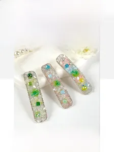 Three crystal-encrusted BB hair clips with colorful gemstones and diamond-edged details