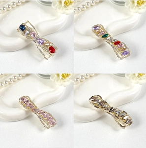 Detailed grid view of four bow-shaped crystal hair clips in various vibrant color schemes