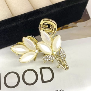 Detail of clover hair claw clip with opal stones and sparkling rhinestones