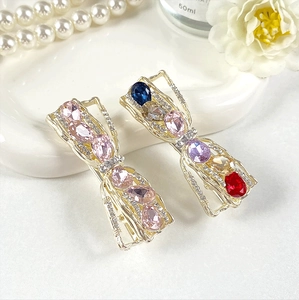 Close-up of alloy bow hair clips with pink and colorful crystal rhinestones