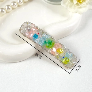 Rectangle crystal hair clip with colorful beads and floral details on a white tray
