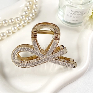 Dettaglio del fermaglio per capelli in acrilico ambra con strass lucidi e molla dorata
