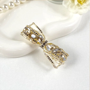 Detailed view of an elegant butterfly hair clip featuring clear crystals on a white ceramic tray