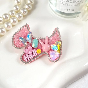 Gros plan d'une barrette à cheveux rose avec des strass et des charms mignons