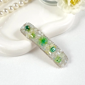 Detail of green crystal rectangle hair clip with hand-beaded stones and silver rhinestones