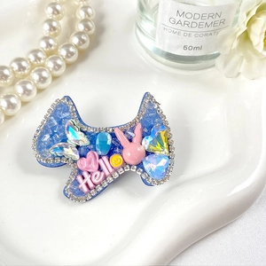 Détail de la barrette nœud bleu avec strass brillants, lapin rose et texte Hello