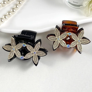 Detail of floral hair claw clips with rhinestones in black and amber tortoise shell colors