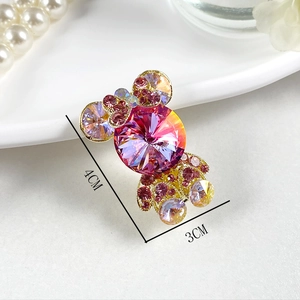 Détails d'une broche en forme de bonbon avec cristaux roses et strass K9 brillants