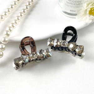 Gray K9 crystal hair clips in dark brown and black resin shown in a lifestyle setting