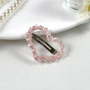 Détail de la pince à cheveux en perles de cristal en forme de cœur rose et cadre argenté