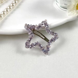 Vue rapprochée de la barrette étoile en perles violettes sur une assiette en porcelaine