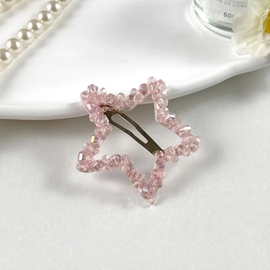 Détail d'une pince à cheveux étoile en perles de cristal rose avec des accessoires