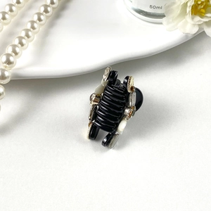 Detailed close-up of a French style mini hair claw with elegant pearl and rhinestone accents