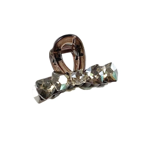 Elegant grey K9 crystal hair claw with smoke-colored gemstones on a smoky resin base