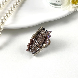 Elegant hair claw clip with purple flowers and crystals on a white luxury setting