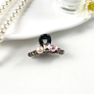 Detailed close-up of a French mini hair claw with pearls, crystal and pink flower