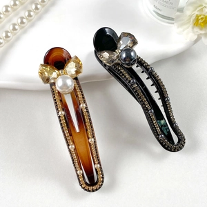 Elegant leopard print hair clips with crystal bows and pearls in amber and black