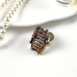 Mini pince à cheveux ambre élégante avec strass et perles sur fond blanc brillant