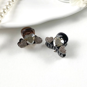 Detail of mini heart hair claws with sparkling rhinestones in amber and black