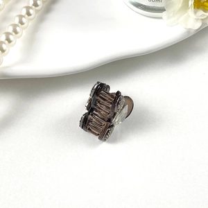 Detail of small brown hair claw clip with sparkling rhinestones and crystal flower design