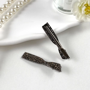 Dettaglio di fermagli per capelli con strass grigio scuro e design a fiocco
