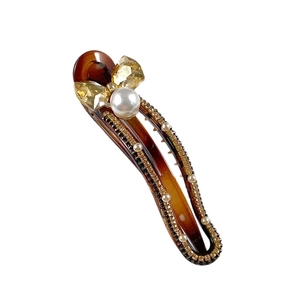 Amber leopard print hair clip with crystal bow and pearl accent on white background