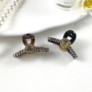 Detail of mini hair clips with sparkling rhinestones in black and amber resin finish