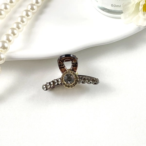Detailed view of luxury rhinestone mini hair claw clip with golden crystal accents