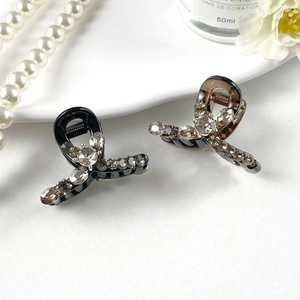 Detail of mini resin hair claws with grey rhinestones in black and amber colors