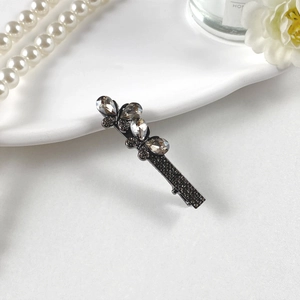 Dettaglio ravvicinato di una clip per capelli a farfalla con strass grigi su bianco