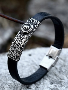 Nahaufnahme der Lederarmband-Seite mit Löwenkopf und strukturierter silberner Schnalle