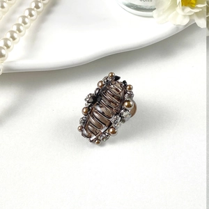 Detail of elegant amber hair claw clip with white pearls and sparkling rhinestones