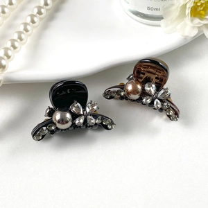 Close-up of sparkling rhinestone flower hair clips with pearls on a white background