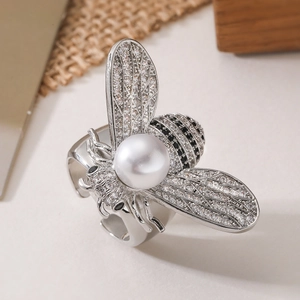 Adjustable silver bee ring with white pearl and sparkling zircon on natural wood