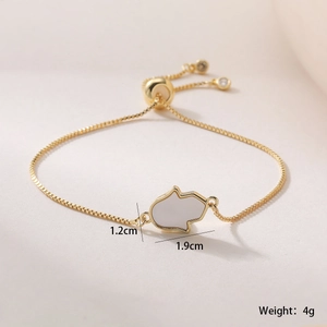 Gros plan détaillé du bracelet main de Hamsa plaqué or 18 carats avec incrustation blanche