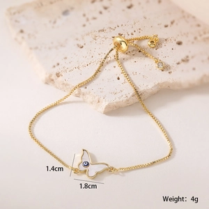 Détail du bracelet papillon doré 18K avec incrustation œil grec et breloque de 1,4 cm